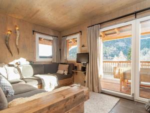 een woonkamer met een bank en een balkon bij De Berghut in Stadl an der Mur