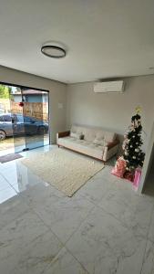 a living room with a couch and a christmas tree at Casa da Praia Bem Viver in Santa Cruz Cabrália