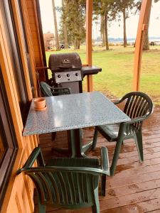 a table and chairs on a porch with a grill at Oyster Bay Resort in Oyster Bay