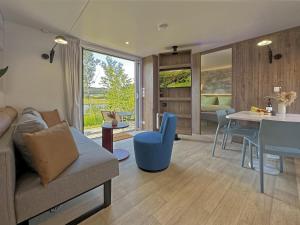 ein Wohnzimmer mit Sofa und Tisch in der Unterkunft Feriendorf Seeblick - Tiny Chalet Nr 3 in Neunburg vorm Wald