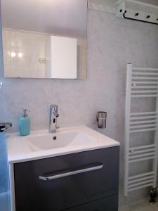 W łazience znajduje się umywalka i lustro. w obiekcie Apartment Elena w Pireusie