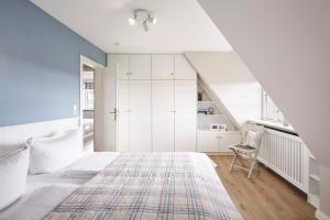 una camera da letto bianca con un letto e una scala di Haus Seefahrer 1 a Goting