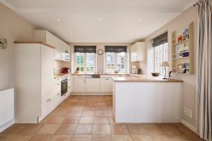 una cucina con mobili bianchi e pavimento piastrellato di Haus Seefahrer 1 a Goting Altre 15 foto