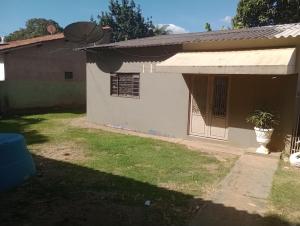 a house with a porch with a plant in the yard at quarto colhao casal no chao in Chapada dos Guimarães