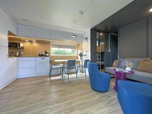 ein Wohnzimmer und eine Küche mit Sofa und Tisch in der Unterkunft Feriendorf Seeblick - Tiny Chalet Nr 6 in Neunburg vorm Wald