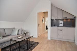 a living room with a couch and a kitchen at Luv & Lee, Whg 11a in Westerland