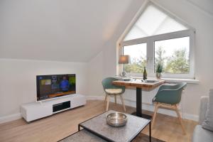 a living room with a table and a tv at Luv & Lee, Whg 11a in Westerland