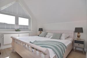 a white bedroom with a large bed with a window at Luv & Lee, Whg 11a in Westerland