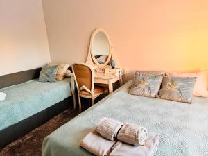 two beds in a room with a mirror and a desk at Vabaduse apartment in Võru