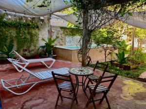 een terras met een tafel en stoelen en een zwembad bij Casa X'Lapac in Valladolid