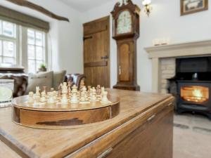 a chess board on top of a wooden table with a clock at Narrowgates Cottage in Barrowford