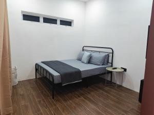 a bed in a room with a white wall at Rumah Comel Temerloh Studio in Temerloh