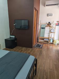a bedroom with a bed and a tv on a wall at Rumah Comel Temerloh Studio in Temerloh