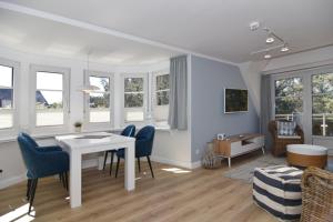a living room with a table and chairs and windows at Luv & Lee, Whg 10 in Westerland