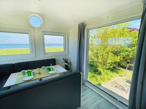 a dining room with a table and a view of the ocean at Strandhaus James Cook Teichhof Fehmarn in Wenkendorf