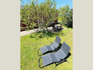 two white chairs sitting on the grass in a yard at Strandhaus James Cook Teichhof Fehmarn in Wenkendorf