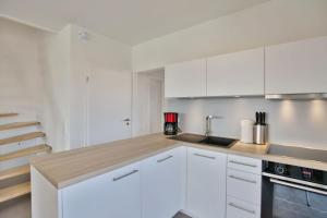 a white kitchen with white cabinets and a sink at City Marina, CM16c in Cuxhaven