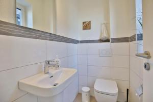 a white bathroom with a sink and a toilet at City Marina, CM16c in Cuxhaven +16 photos