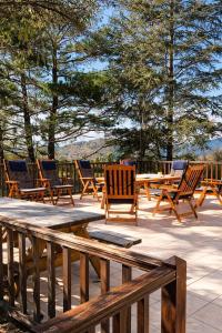 een groep houten stoelen en tafels op een patio bij Forest Park Villa in Lemithou