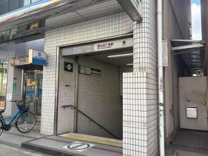 einen Eingang zu einem Gebäude mit einem Fahrrad, das draußen geparkt ist in der Unterkunft 品闲居 in Osaka