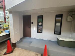 zwei orangefarbene Verkehrskegel vor einem Laden in der Unterkunft 品闲居 in Osaka