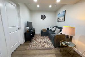 a living room with a couch and a clock on the wall at Sleek Guest Retreat SW EDM BSMT Suite in Edmonton