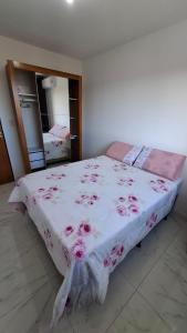 a bedroom with a bed with pink flowers on it at Apartamento em Jacumã in Conde +6 photos