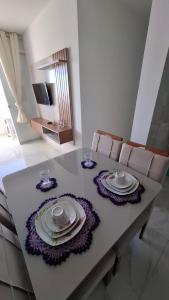 a dining room table with plates and dishes on it at Apartamento em Jacumã in Conde