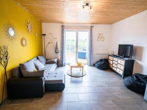a living room with a couch and a tv at Appartement Terrasse Jacuzzi du Pont Alsort 2-1 in Froid-Chapelle