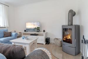 a living room with a fireplace and a tv at Wynkaat in Nieblum