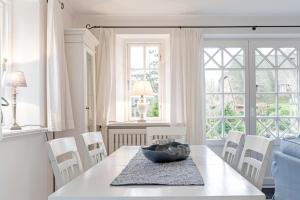 a white dining room with a table and chairs at Wynkaat in Nieblum