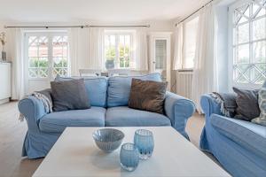 a living room with a blue couch and a table at Wynkaat in Nieblum