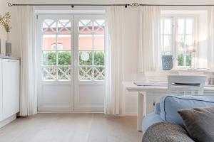 a white living room with a door and a table at Wynkaat in Nieblum +25 photos