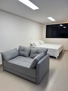 een woonkamer met een bank en een bed bij Studio Connect Life in Teresina