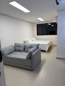 een woonkamer met een bank en een bed bij Studio Connect Life in Teresina