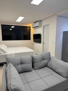 een woonkamer met een bank en een bed bij Studio Connect Life in Teresina