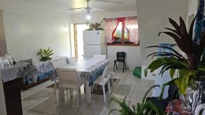a dining room with a table and a refrigerator at Le Pavillon des îles in Te-Fare-Arii