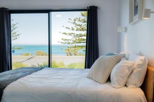 a bedroom with a bed with a view of the ocean at Fairy Wren in Kingscote