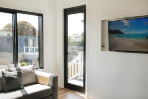 a living room with a sliding glass door with a tv at Fairy Wren in Kingscote