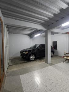 a parking garage with a car parked in it at Fatmara Villa Full House in Kejajar +2 photos