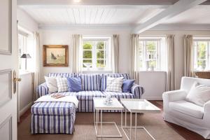 un soggiorno con divano e sedie blu e bianche di Sanfte Brise 1- links a Oevenum