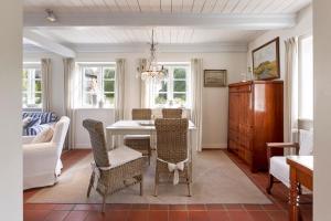 una sala da pranzo con tavolo, sedie e divano di Sanfte Brise 1- links a Oevenum Altre 17 foto