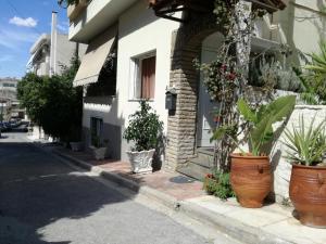 a house with large pots of plants on the sidewalk at Agapi's Two Levels Studio in Athens