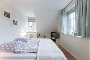una camera da letto bianca con un letto e una televisione di Haus Landleben a Goting