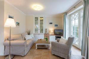 un soggiorno con divano, sedie e TV di Haus Landleben a Goting