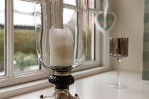 un vaso di vetro con una candela accanto a una finestra di Haus Landleben a Goting Altre 20 foto