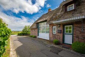 an old brick house with a thatched roof at Mawe Huus in Oldsum