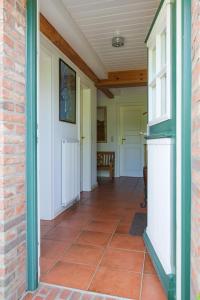 a hallway of a house with a tile floor at Mawe Huus in Oldsum