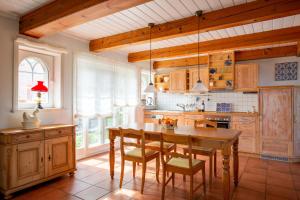 a kitchen with a wooden table and chairs in it at Mawe Huus in Oldsum