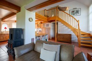 a living room with a couch and a staircase at Mawe Huus in Oldsum +8 photos